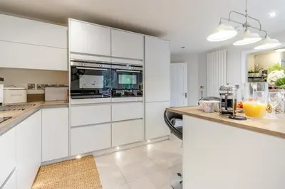 a kitchen with white cabinets and a counter with orange juice at 3 Bed in Brithdir oc-c33971 in Llanfachreth