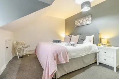 a bedroom with a large bed and a chair at 3 Bed in Brithdir oc-c33971 in Llanfachreth