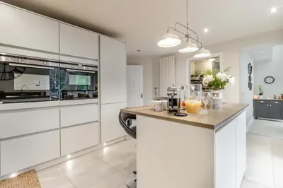 a kitchen with white cabinets and a counter with drinks on it at 3 Bed in Brithdir oc-c33971 in Llanfachreth