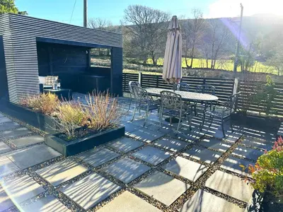 a patio with a table and an umbrella at 3 Bed in Brithdir oc-c33971 in Llanfachreth