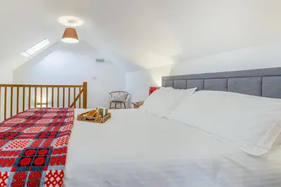 a bedroom with a white bed with a plaid blanket at 1 Bed in Llangower oc-t34142 in Llangower