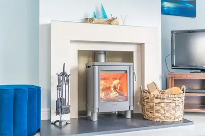 a fireplace with a stove in a living room at Ty-Mari in Harlech