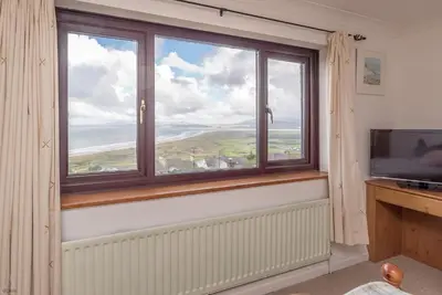 a room with a large window and a television at Ty-Mari in Harlech