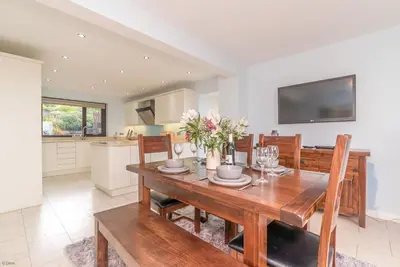 a kitchen and dining room with a wooden table and chairs at Ty-Mari in Harlech