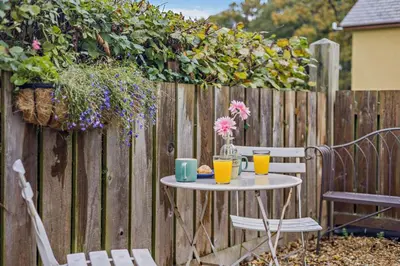a table with two drinks on it next to a fence at 1 Bed in Cilmery oc-g32770 in Builth Road