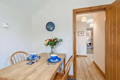 a dining room table with a vase of flowers on it at 1 Bed in Cilmery oc-g32770 in Builth Road