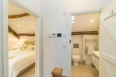 a white bedroom with a bed and a toilet at Coed-Stable in Dolgellau
