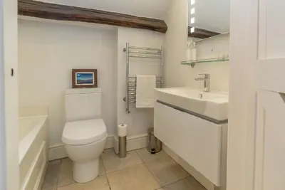 a white bathroom with a toilet and a sink at Coed-Stable in Dolgellau