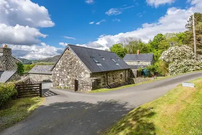 a road leading to a stone house on a hill at Coed-Stable in Dolgellau