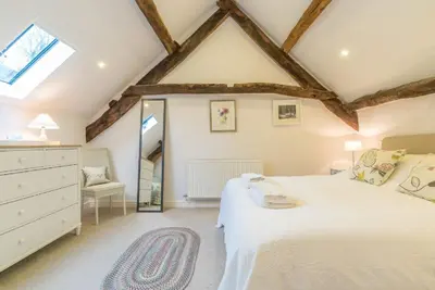 a bedroom with a white bed and a window at Coed-Stable in Dolgellau