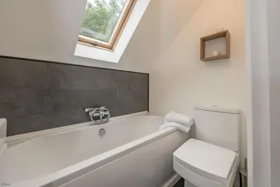 a bathroom with a white toilet and a bath tub at Erw-Fair in Arthog