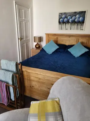 a bedroom with a bed with blue pillows and a chair at 23a High Street Knighton in Knighton