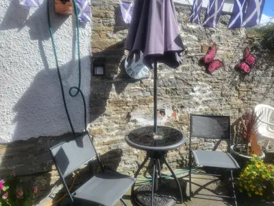 a patio with two chairs and a table and an umbrella at 23a High Street Knighton in Knighton