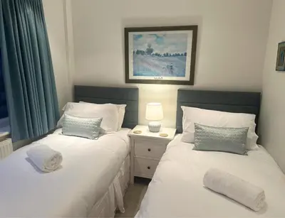 two twin beds in a room with a window at Terrace by the Tide in Aberdyfi
