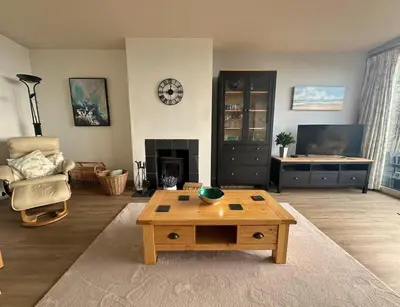 a living room with a coffee table and a fireplace at Terrace by the Tide in Aberdyfi