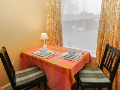 a dining table with two chairs and a window at 6 Church Lane in Llanidloes