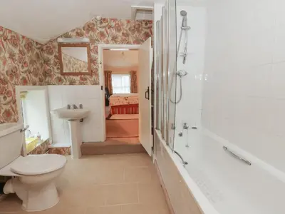 a bathroom with a toilet and a tub and a sink at 6 Church Lane in Llanidloes
