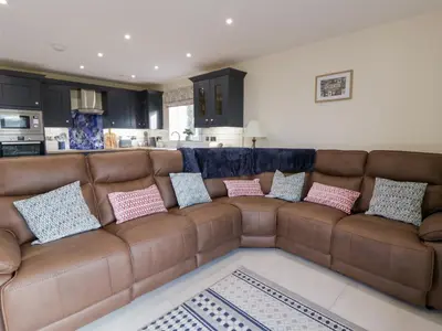 a brown couch in a living room with pillows on it at Beudy in Aberystwyth