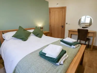 a bedroom with a bed with towels on it at Beudy in Aberystwyth