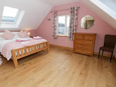 a bedroom with a bed and a dresser and a mirror at Beudy in Aberystwyth