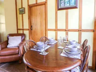 a dining room table with chairs and a table at Maggie's Barn in Brecon