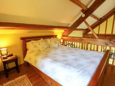 a bedroom with a large bed in a attic at Maggie's Barn in Brecon