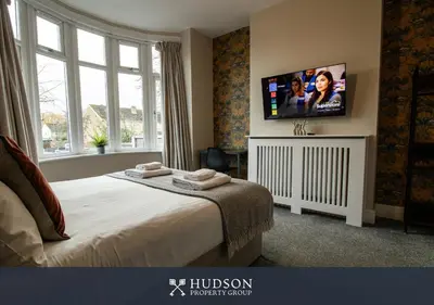 a bedroom with a bed and a flat screen tv at Modern 5 Bedroom Home in Shrewsbury in Shrewsbury