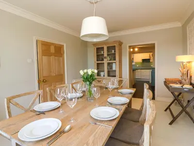 a dining room with a wooden table with glasses at Zenobia in New Quay