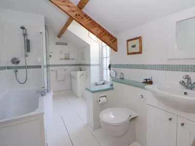 a white bathroom with a sink and a toilet at Zenobia in New Quay