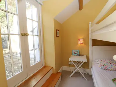 a bedroom with a bunk bed and a window at Zenobia in New Quay