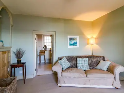 a living room with a couch and a table at Zenobia in New Quay