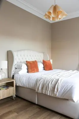 a bedroom with a white bed with two orange pillows at Luxury Apartment in Shropshire sleeps 6 in Shrewsbury