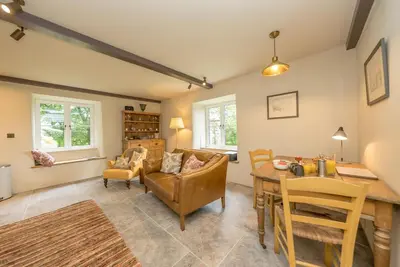 a living room with a couch and a table at Deer-Park-Lodge in Llanfachreth