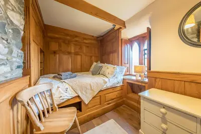 a bedroom with a bed and a chair in it at Hywel-Sele-Lodge in Llanfachreth