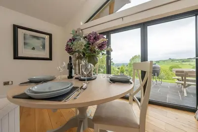 a dining room with a table with a vase of flowers at Llety-Hiraeth in Montgomery