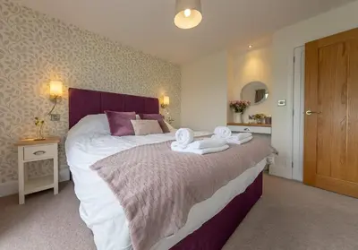 a bedroom with a large bed with towels on it at Llety-Hiraeth in Montgomery