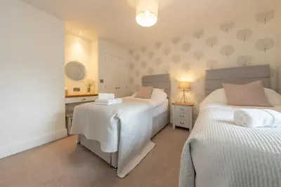 a bedroom with two beds and a table with a lamp at Llety-Hiraeth in Montgomery
