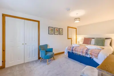 a bedroom with a bed and a blue chair at 3 Bed in Rhydyfelin oc-c34178 in Rhyd-y-felin