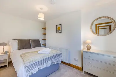 a bedroom with a bed and a dresser and a mirror at 3 Bed in Rhydyfelin oc-c34178 in Rhyd-y-felin