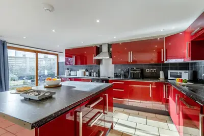 a kitchen with red cabinets and a counter top at 3 Bed in Rhydyfelin oc-y34179 in Rhyd-y-felin