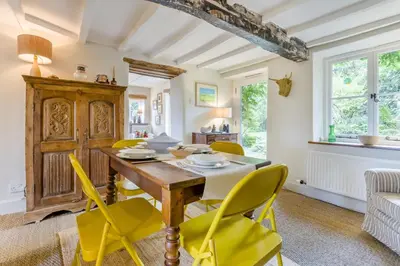 a dining room with a wooden table and yellow chairs at 3 Bed in Newton St. Margarets oc-o33367 in Saint Margaret