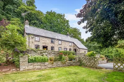 an old stone house with a garden in front of it at 2 Bed in Llandefalle oc-n32991 in Llandefalle