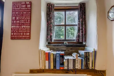 a shelf of books in front of a window at 2 Bed in Llandefalle oc-n32991 in Llandefalle