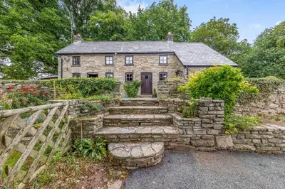 an old stone house with a stone staircase in front of it at 2 Bed in Llandefalle oc-n32991 in Llandefalle