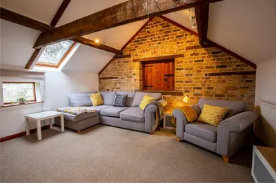 a living room with two couches and a brick wall at Y Beudy