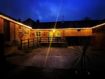 a brick building with lights on it at night at Y Beudy