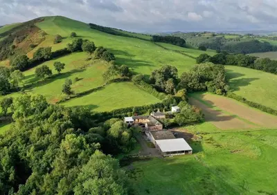 an aerial view of a house on a green hill at Y Beudy