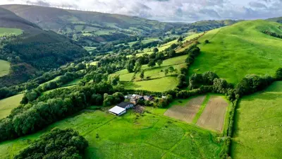 an aerial view of a farm in a green field at Penrhyllan
