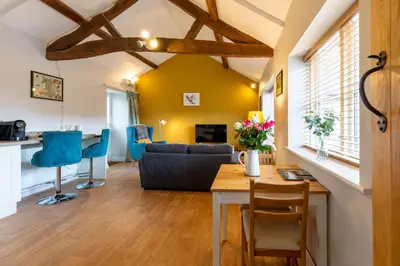 a living room with a table and blue chairs at Penrhyllan