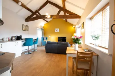 a kitchen and living room with a table and a couch at Penrhyllan